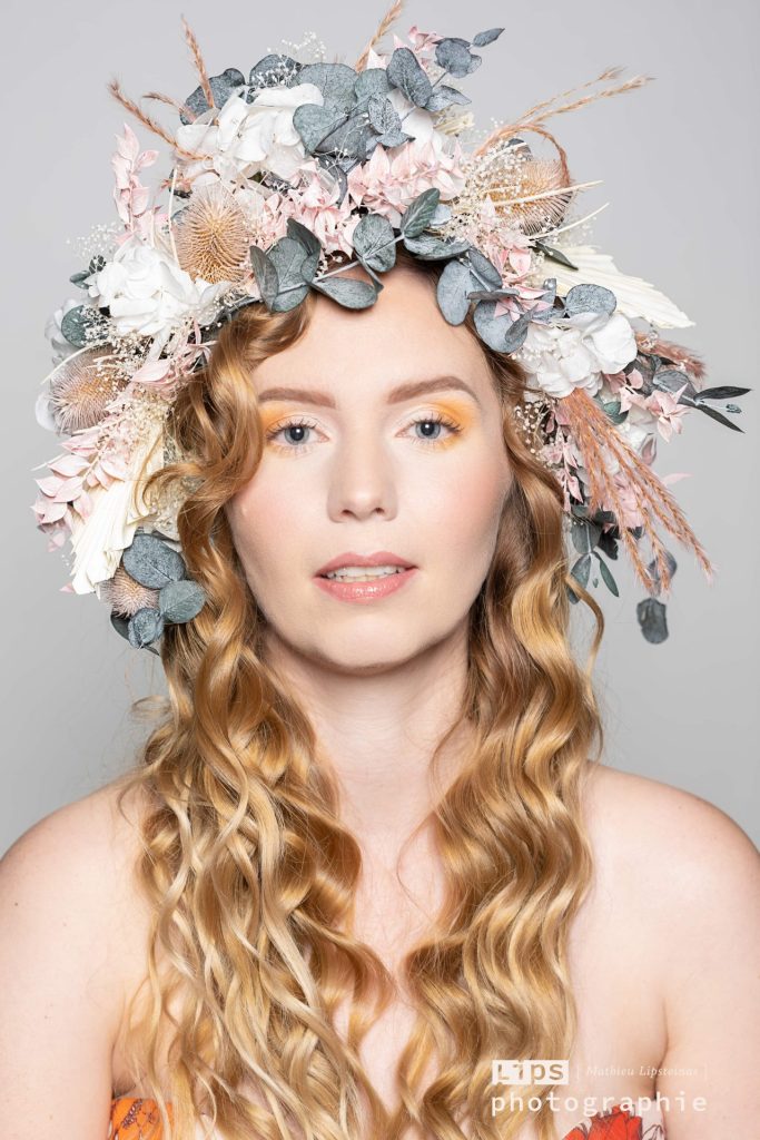 Portrait de studio d'une jeune femme entourée de papier blanc, série artistique