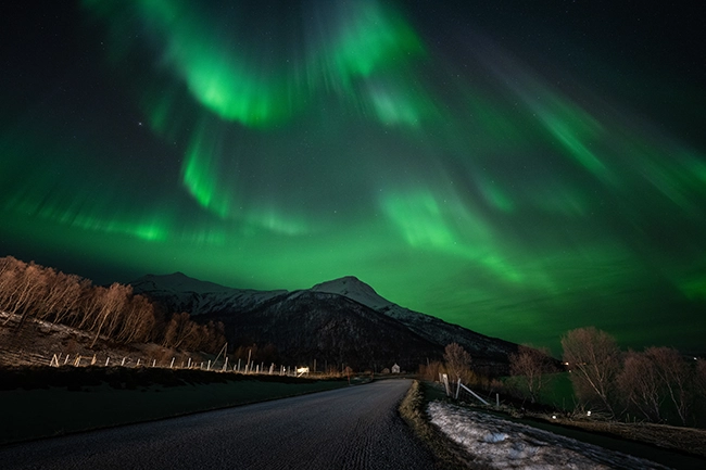 Aurore boréale verte au-dessus d'un lac gelé, voyage photo en Laponie