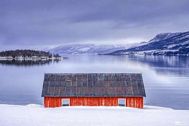 Cabane rouge traditionnelle au bord d'un fjord, Laponie norvégienne