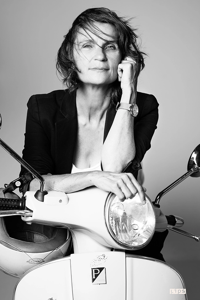 Femme d'affaire qui pose sur un scooter les cheveux au vent