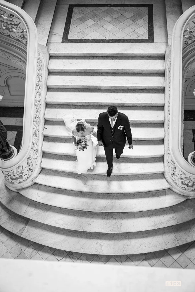 Mariés descendant le grand escalier de pierre d'un château