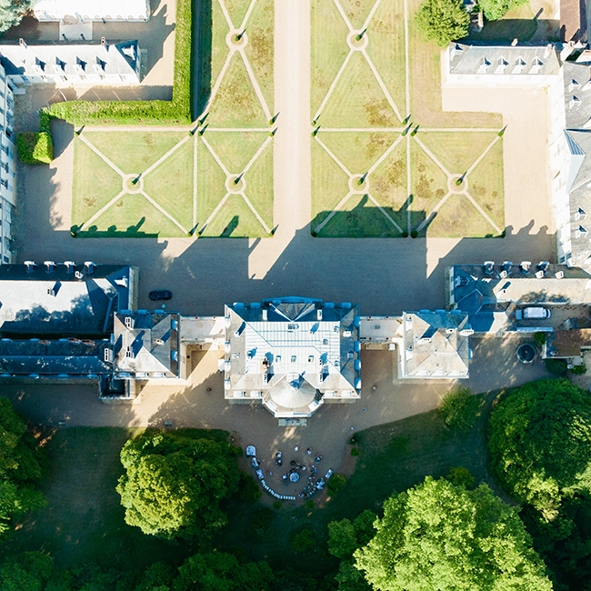 Vue aérienne d'un château de réception de mariage et de ses jardins à la française