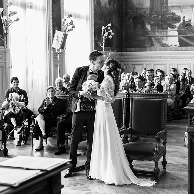 Cérémonie de mariage dans le grand salon d'un château devant les invités assis