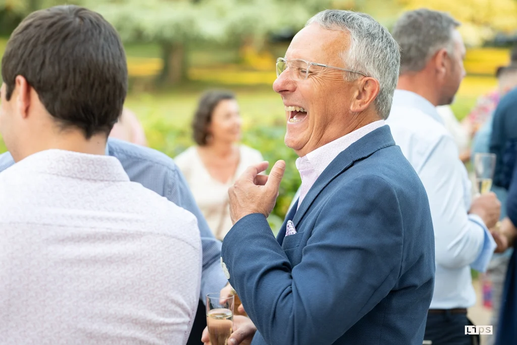 Dirigeant en costume échangeant avec ses invités lors d'un cocktail d'entreprise