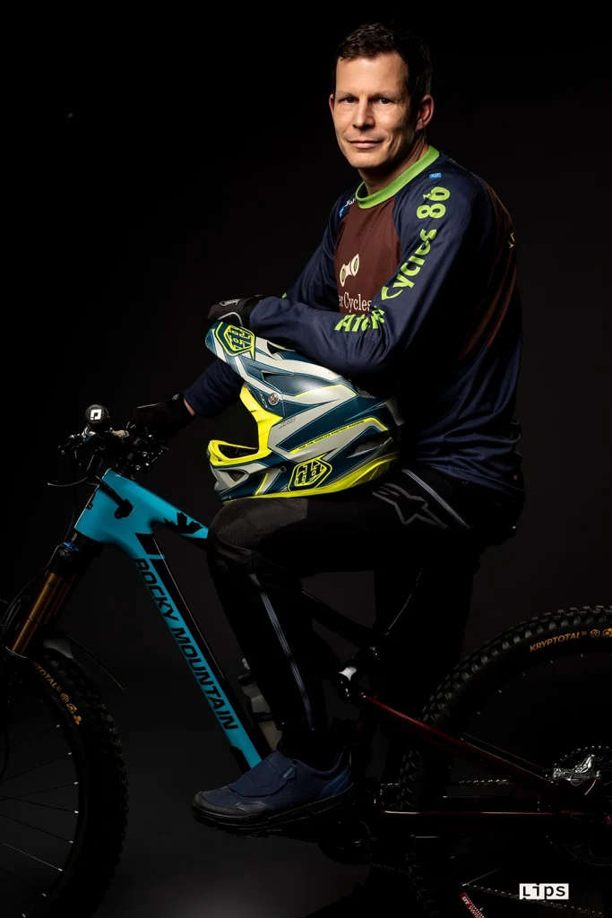 Cycliste VTT en tenue fluo photographié en studio sur fond noir, visuel publicitaire