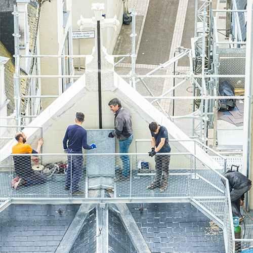 Ouvriers au travail sur une passerelle métallique dans un site industriel