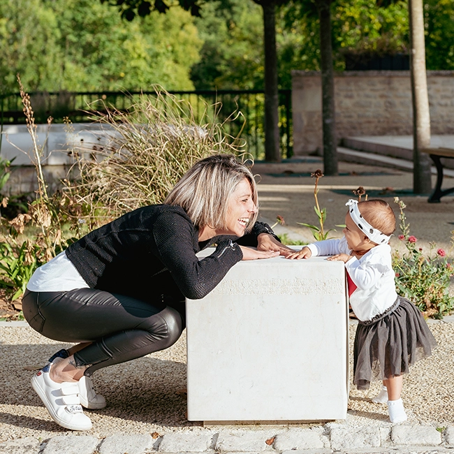 Une femme et une petite fille jouent de part et d'autre d'un cube blanc, séance famille