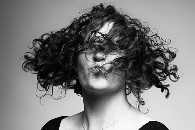 Portrait en noir et blanc d'une femme aux cheveux bouclés en mouvement