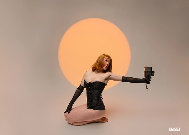 Portrait de studio devant un cercle lumineux orange, mise en scène publicitaire