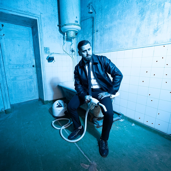Portrait en situation dans une pièce désafectée ou salle de bain carrelée, en lumière bleue