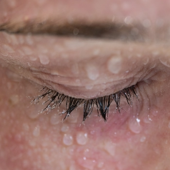 Macro d'un œil aux cils perlés de gouttelettes, photographie de détail