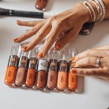 Mains disposant des flacons de cosmétiques sur un plan noir, photographie produit